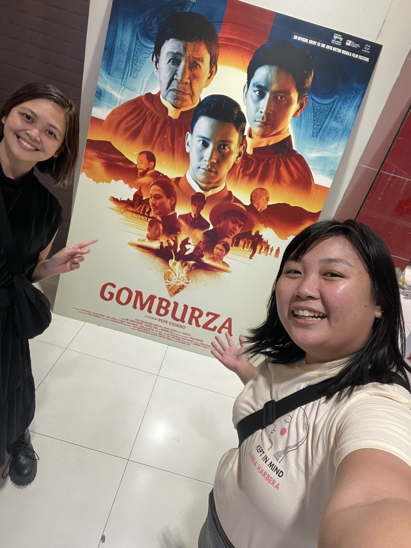 Selfie of Chi and Karen in front of the big movie poster for GomBurZa.