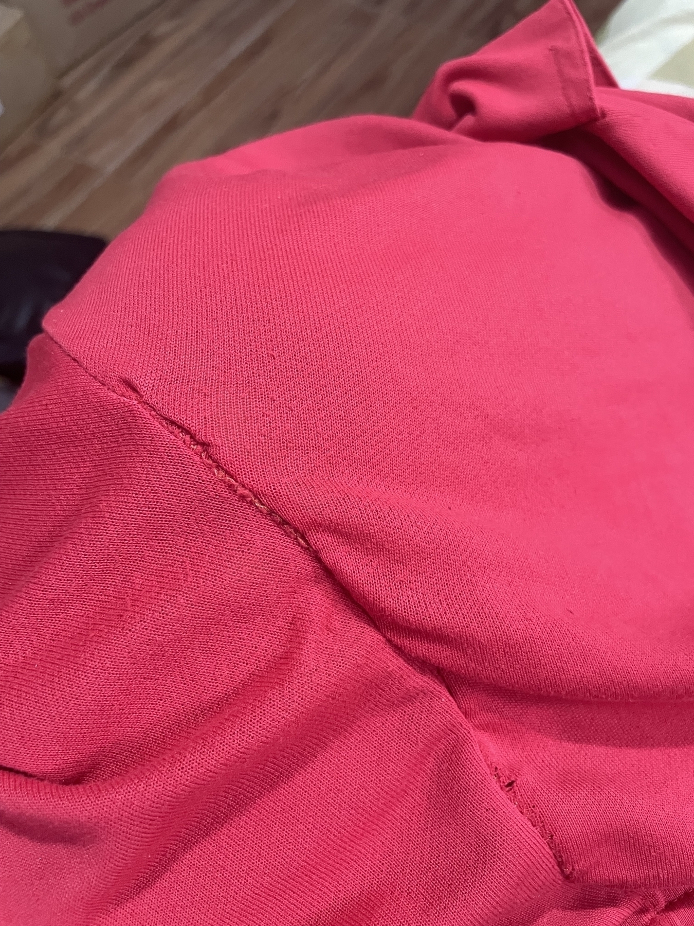 Chi's red shorts that previously had a hole in it, now sewn back closed. Some of the threads used in her patchwork are visible, and the sewing isn't that clean, but the hole is not present anymore.