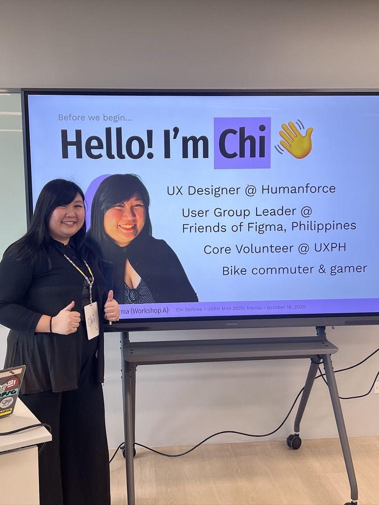 I didn’t realize I wore the same exact outfit as the photo of myself on my intro slide 😆 Chi posing next to her photo on her intro slide for her workshop with both her thumbs up. She is wearing a black cardigan only buttoned at the top, a polka dot top, black wavy slacks, and her conference ID lanyard. Her photo on the intro slide shows her in the exact same outfit, but only showing half body and with slightly shorter hair.