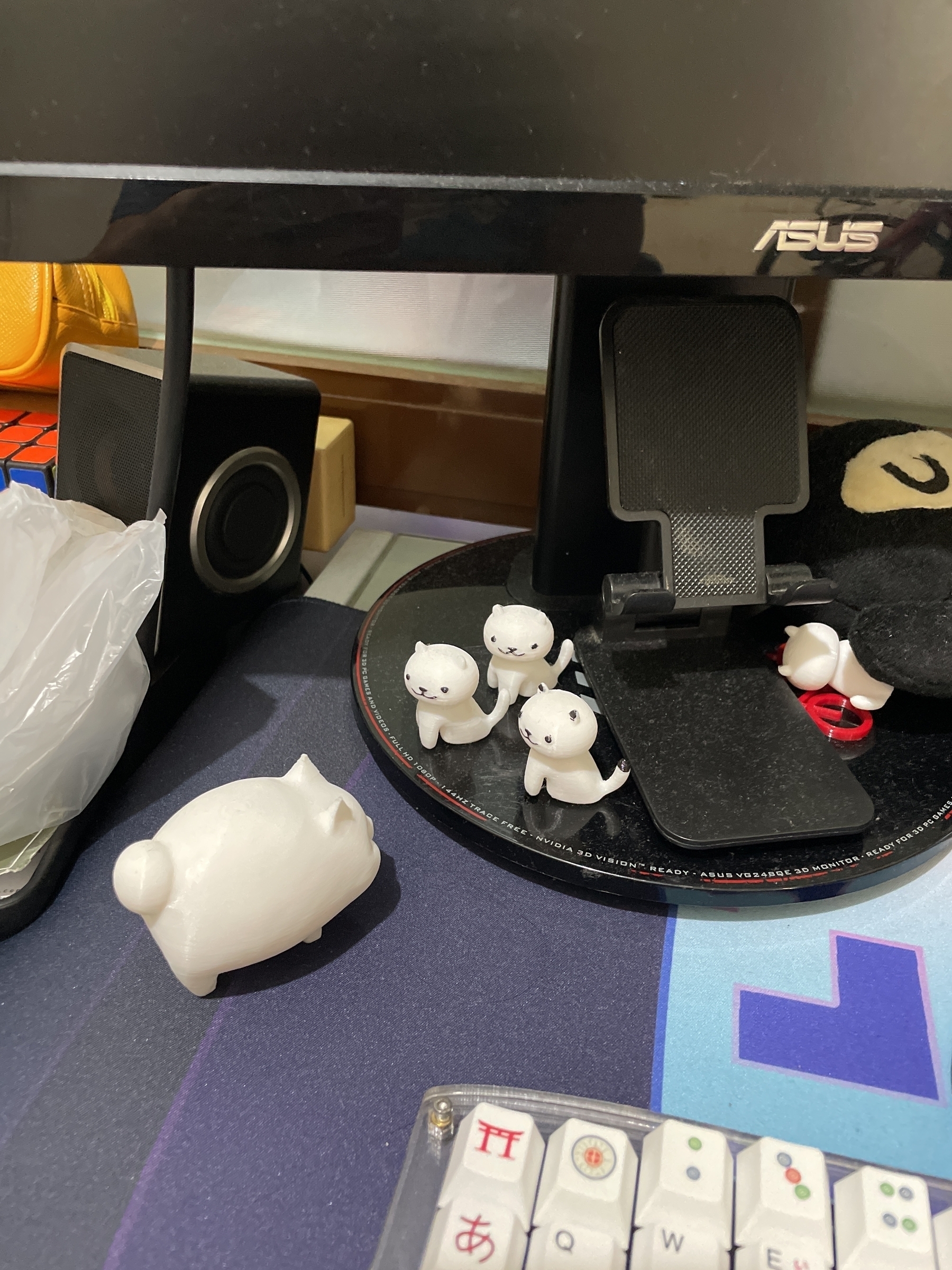 3 3d-printed small cats are found facing a 3d-printed fat cat on Chi’s desk. The small cats are on the monitor stand.